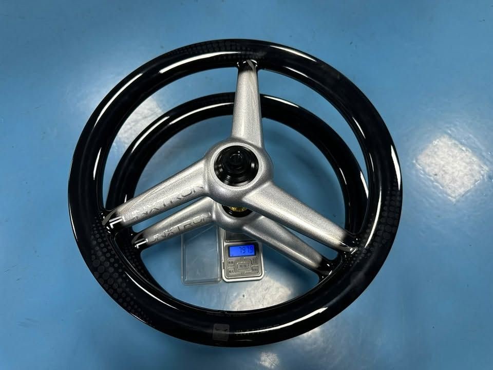 Suncord tri-spoke carbon wheelset for Funxtron F16 in black with silver spokes weighed as a pair on a digital scale reading 797 g